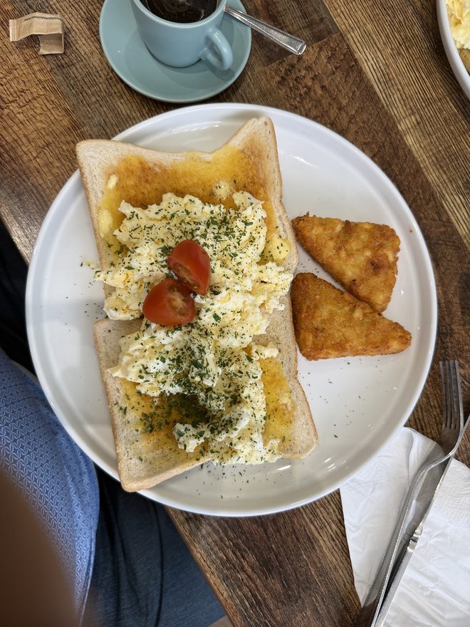 Scrambled egg on toast with a blue cup of coffee